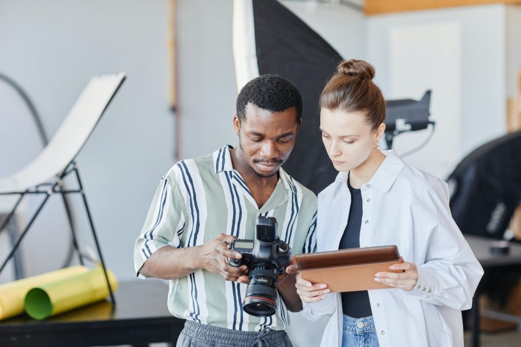 Photographers Looking At Images In Camera